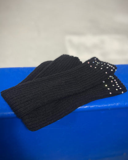 A pair of black leg warmers with crystal embellishments on the top